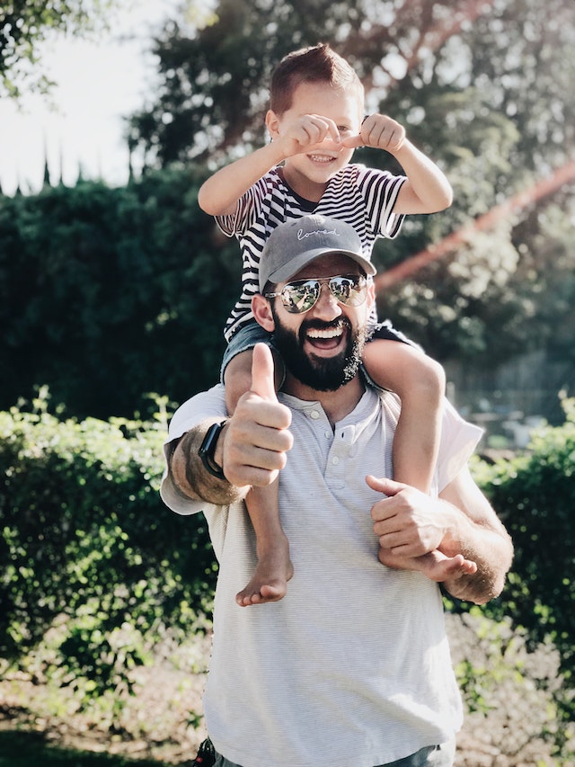man with kid on shoulders man with kid on shoulders